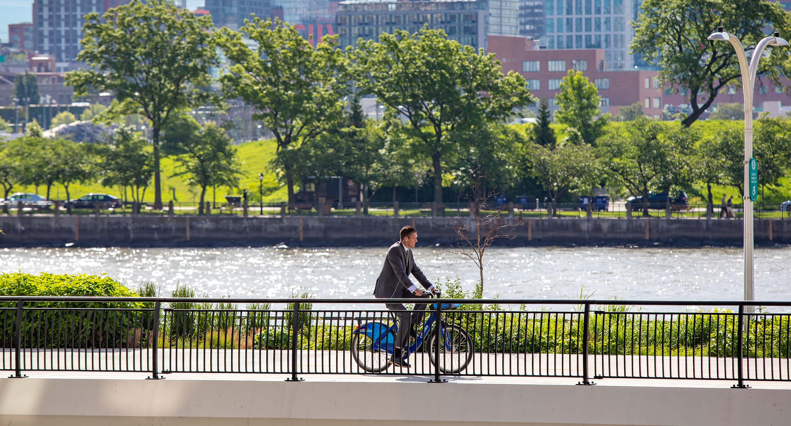 Cyclist Biking along the East River near The Lotus NYC in Murray Hill, offering easy outdoor access from the waterfront.